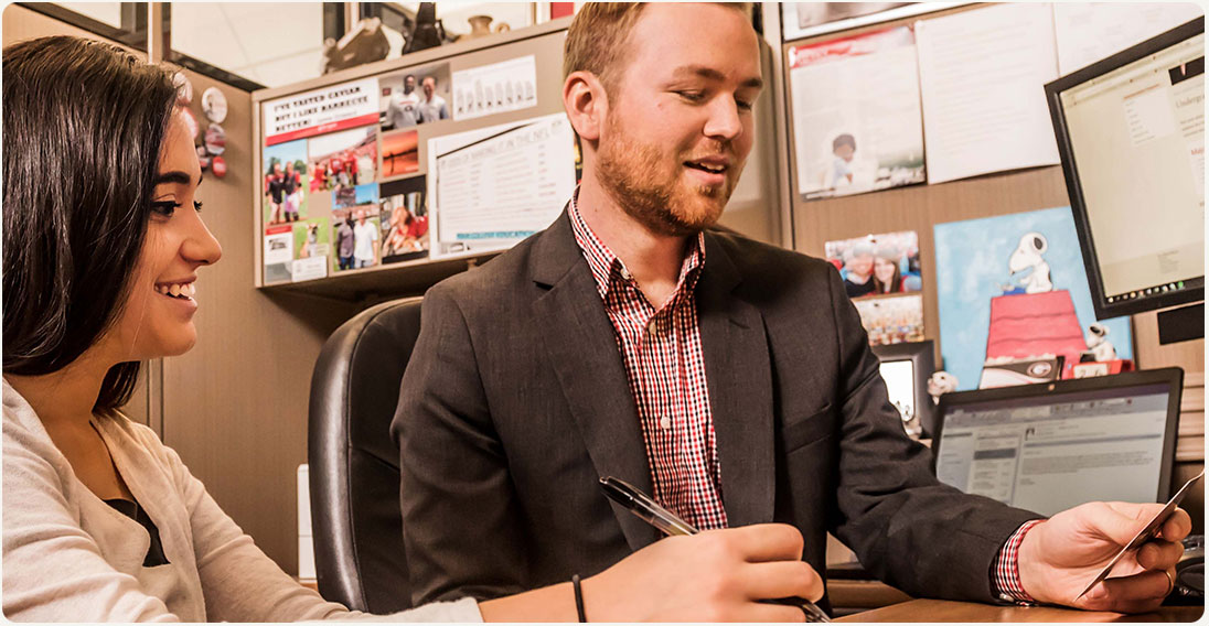 An advisor happily working with a student